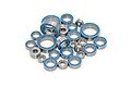 A collection of various sized metal ball bearings with blue rubber seals arranged on a white background.