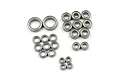 A collection of various sized metal shielded ball bearings arranged on a white background.