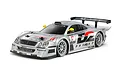 A studio shot of a 1/10 scale Tamiya Mercedes-Benz CLK-GTR RC car in silver with Warsteiner racing livery, shown from a front three-quarter angle.