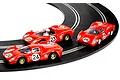 Three red Scalextric 1/32 scale slot cars numbered 23, 24, and 26 racing on a curved black slot car track.