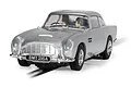 A 1/32 scale Scalextric James Bond Aston Martin DB5 slot car in silver, featuring the iconic BMT 216A license plate, sitting on a slot car track.