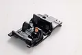 A black plastic RC car interior cockpit set with a single driver figure seated in the front, isolated on a white background.