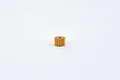 A small brass pinion gear with multiple teeth centered on a plain white background.