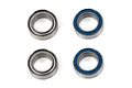 Four Factory Team ball bearings, two with metal shields and two with blue rubber seals, arranged on a white background.