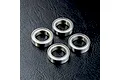 Four metal shielded ball bearings arranged on a textured black surface.