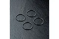 Four black rubber O-rings arranged on a textured black surface.