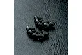 A group of ten black button head hex screws arranged on a textured black surface.