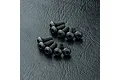 A collection of ten black metal button head screws with hex sockets arranged on a textured black surface.