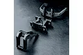 Three black plastic RC chassis components from MST arranged on a textured black surface.