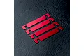Four red anodized metal suspension mount spacers arranged diagonally on a black textured surface.
