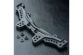 A black MST rear shock tower for an RC car, featuring multiple mounting holes and four small circular spacers, set against a textured black background.