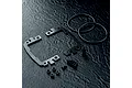 MST Carbon Fibre Battery Mount Set components including carbon plates, O-rings, screws, and spacers on a dark textured surface.