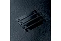 Four black rectangular MST suspension mount spacers with U-shaped cutouts at each end, arranged diagonally on a dark textured surface.