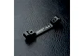 A black aluminium MST suspension arm mount with -2.0 engraved on the top, resting on a dark textured surface.