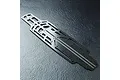 A top-down view of an MST lightweight carbon fibre RC car chassis plate featuring a complex cutout design and a woven carbon fiber texture.