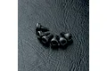 A set of six black metal cap head screws with hexagonal sockets arranged on a textured black surface.