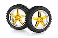 Two 1/10 scale RC buggy front wheels with black knobby rubber tyres mounted on five-spoke orange and chrome plastic rims.