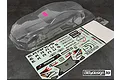 Clear, unpainted Bittydesign Ekanus 1/10 scale RC drag car body shell with a decal sheet and small hardware bag on a dark textured surface.