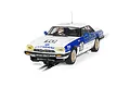 A 1/32 scale Scalextric Jaguar XJS slot car, number 10, featuring Citibank livery on a white and blue body, positioned on a slot car track.