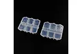 Two clear plastic storage boxes with six individual compartments each, set against a plain black background.