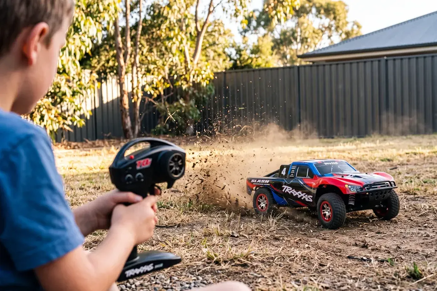 A Traxxas Slash RC truck kicking up dirt in a sunny Australian backyard, controlled by a child.