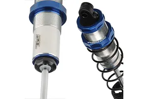 Two close-up views of Pro-Line Pro-Spec RC shock absorbers featuring blue anodized aluminum collars and silver bodies with black springs.