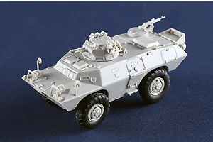 A 1/72 scale plastic model of an M706 Commando armoured car, unpainted in light grey plastic with black wheels, shown from a high-angle perspective.