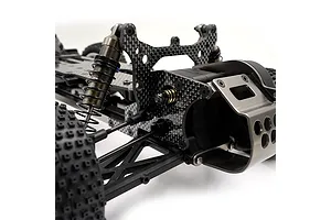 Close-up of an RC car chassis featuring a carbon fiber shock tower, metal shock absorbers, and a metal motor guard.