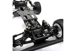 Close-up of an RC car chassis showing the front suspension, shock absorbers, and a graphite front brace plate installed.