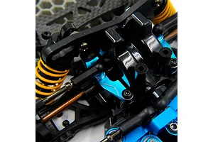 Close-up of blue anodized aluminium suspension components installed on an RC car chassis with yellow shock springs.