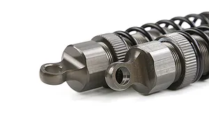 A close-up view of two gunmetal-coloured adjustable RC shock absorbers showing the top mounting points and threaded bodies.