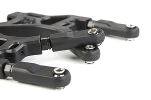 Close-up of black Rovan RC rear lower suspension arms with metal ball joints and plastic components.