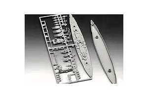 Grey plastic model kit parts for a battleship, including a sprue frame with turrets and the ship deck and hull pieces.