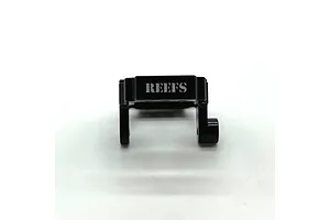 A black anodized aluminium servo mount for RC vehicles with the Reefs RC logo laser-etched on the front, set against a plain white background.