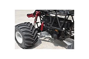 Close-up of the rear suspension and silver lower link bars installed on an RC monster truck chassis.
