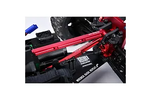 A red GPM Racing aluminium chassis brace installed on an RC vehicle chassis, showing the metal structure and branding.