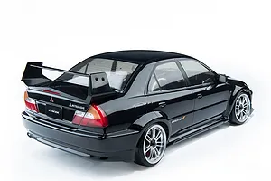 Rear three-quarter view of a black 1/10 scale MST Mitsubishi Lancer Evolution V RC drift car on a white background.