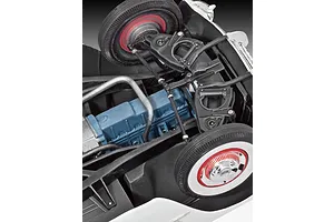 Close-up view of the underside of a 1/24 scale 1953 Chevrolet Corvette model car, showing the blue engine block, front suspension, and wheels.