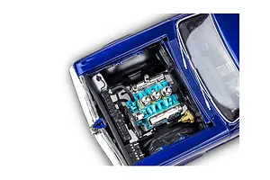 A high-angle close-up of the detailed engine bay of a blue 1964 Pontiac GTO model car kit, showing the turquoise engine block and chrome components.