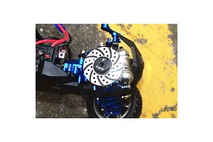 GPM Racing aluminium wheel hex with integrated brake disc detail installed on an RC car chassis.