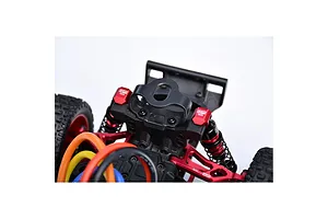 Close-up of red GPM aluminium shock cap protectors installed on an RC car suspension assembly.