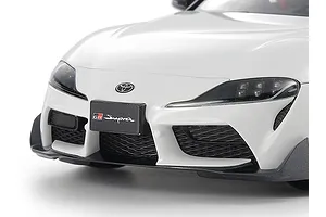 Close-up of the front bumper and headlights of a white Tamiya 1/24 scale Toyota GR Supra plastic model car kit.