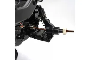 Close-up of an RC car suspension assembly showing a brown spring steel CVD driveshaft installed on a black plastic chassis.