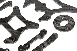 A collection of Rovan carbon fibre RC car parts including shock towers, braces, and a brake disc on a white background.