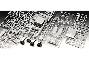 Unassembled grey plastic model car parts on sprues for a 1971 Ford Mustang Boss 351, including the car body, chassis, and four black rubber tires.