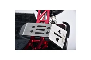 A stainless steel skid plate installed on the front of an RC car chassis with red aluminum suspension arms.