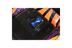 A blue aluminium GPM body shell lock installed on an orange and black patterned RC car body shell.