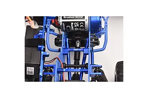 Top-down view of an RC car chassis featuring a blue GPM aluminium upper centre brace bar installed between the frame rails.