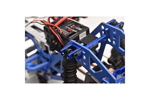 Close-up of a blue anodized aluminium shock mount installed on an RC vehicle chassis, featuring GPM Racing branding.