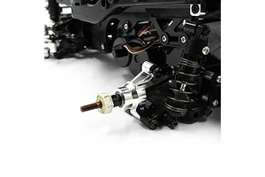 Close-up of a silver aluminium rear hub installed on an RC car chassis, showing the axle, suspension, and surrounding black plastic components.